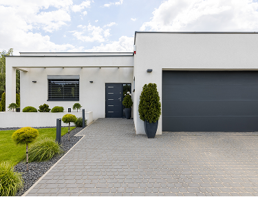 Weißer Bungalow mit ebenerdigem Eingang, Garage und gepflasterter Einfahrt