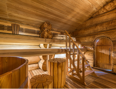 Sauna aus massiven Rundstämmen mit Holzbänken und Badezuber