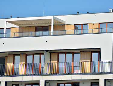 Mehrfamilienhaus mit Holzelementen und durchgehenden Balkonen