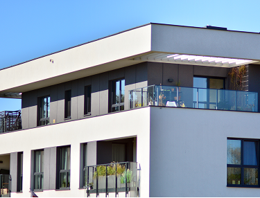 Modernes Mehrfamilienhaus mit Dachterrasse und Glasgeländer