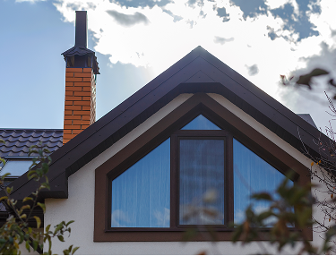 Giebel mit dunklem Dach und großem dreieckigem Fenster